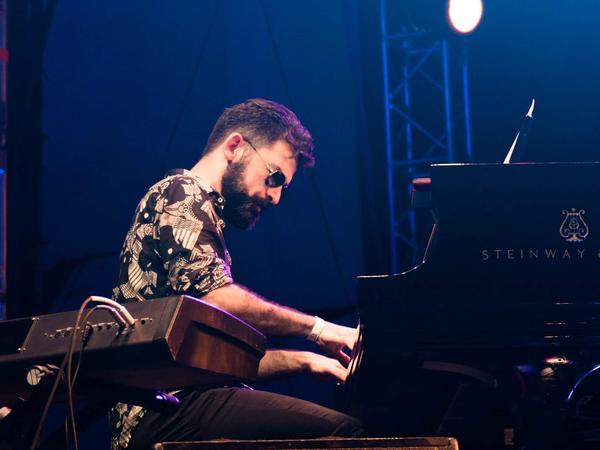 Antonio tocando un piano Steinway bajo luces azules