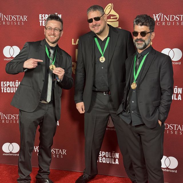 Tres integrantes de Tanghetto con medallas en la alfombra roja